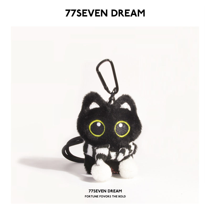 Black cat plush keychain with large yellow-outlined eyes wearing a black-and-white striped scarf