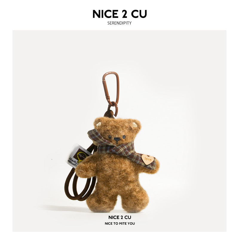 Brown plush bear keychain charm with plaid scarf, heart accent tag, and metal clip attachment