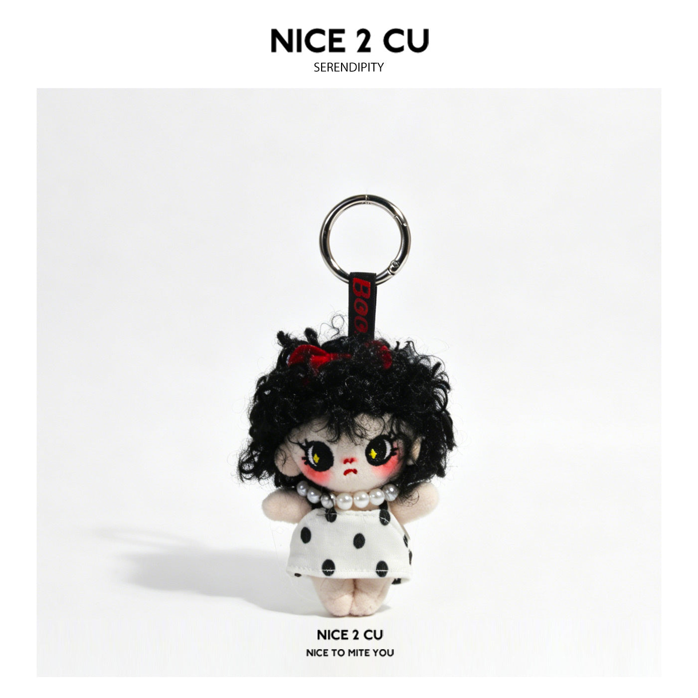 Grumpy girl plush doll keychain charm with curly black hair, white polka-dot dress, and pearl necklace on silver split ring
