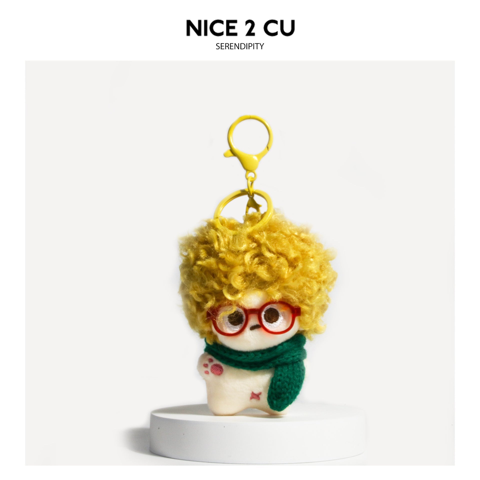 Yellow curly-hair plush doll bag charm with round glasses and dark green knitted scarf, green hanging ring