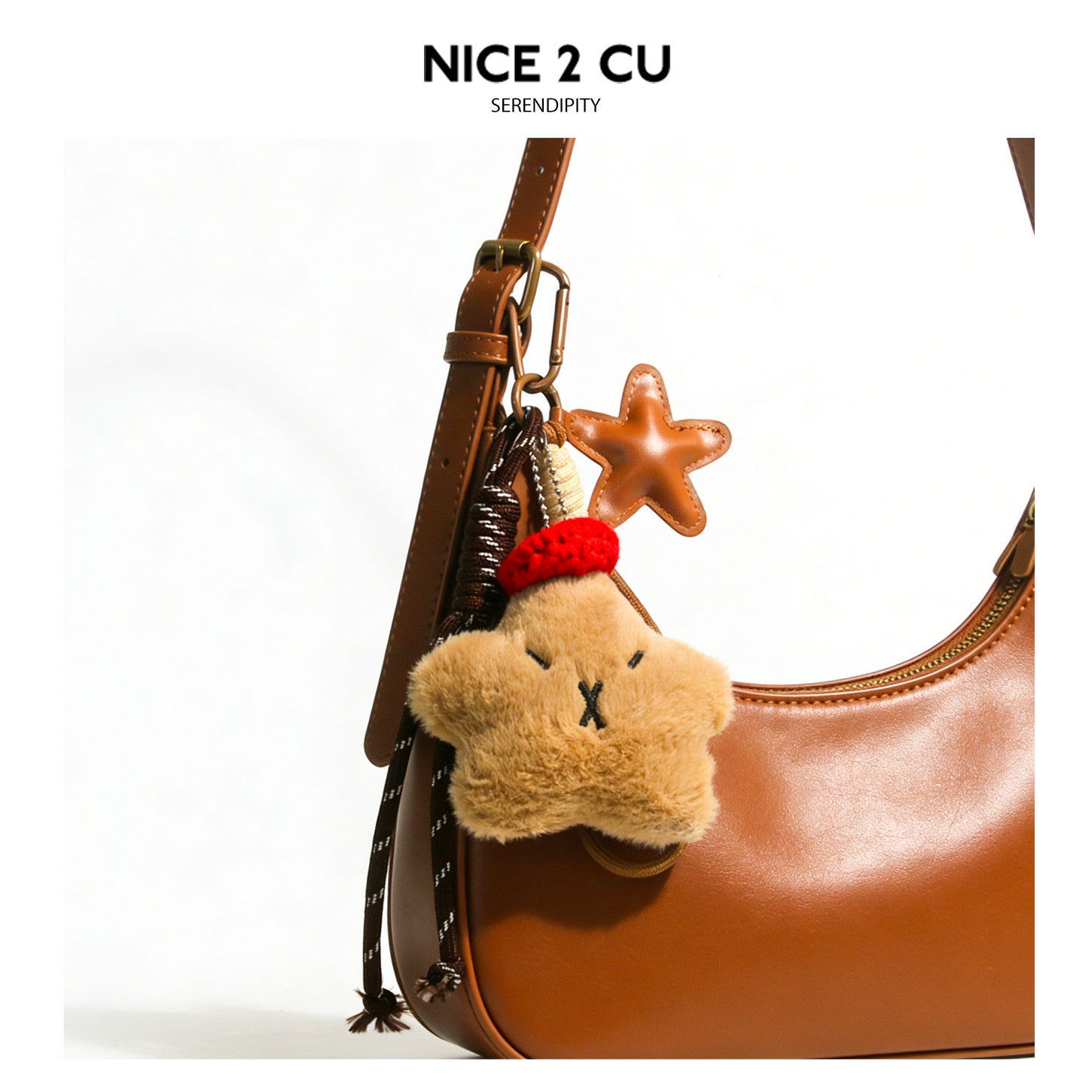 Brown capybara-inspired plush star charm with red knit beret, tan star accent, and metal clip hardware on brown bag strap
