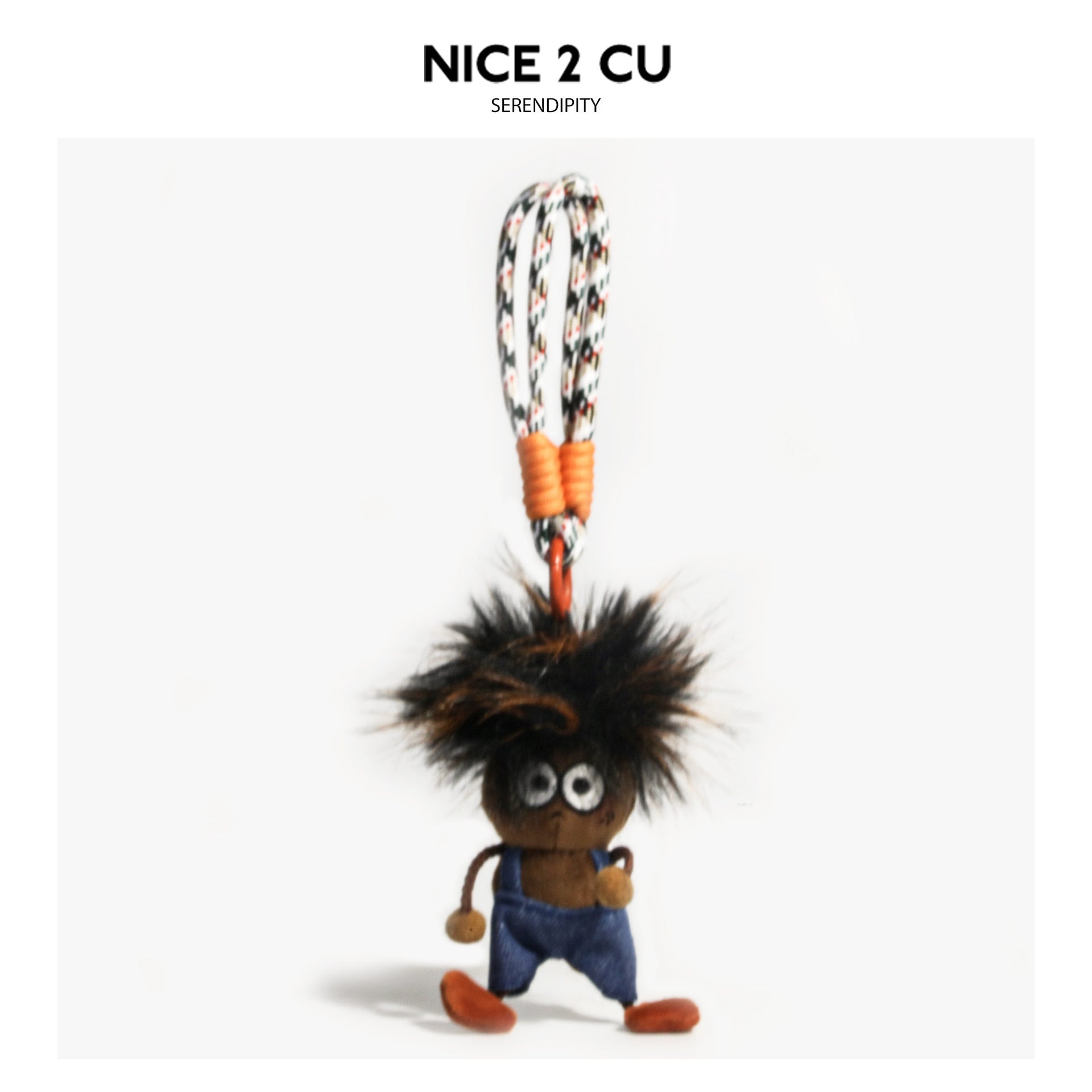 Dark shaggy-haired plush charm wearing blue denim overalls hanging from looped cord