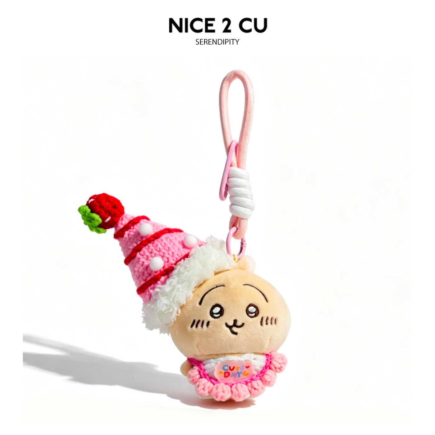 Kawaii cat plush keychain charm with pink strawberry tower hat and ruffled pink outfit on pale pink loop strap