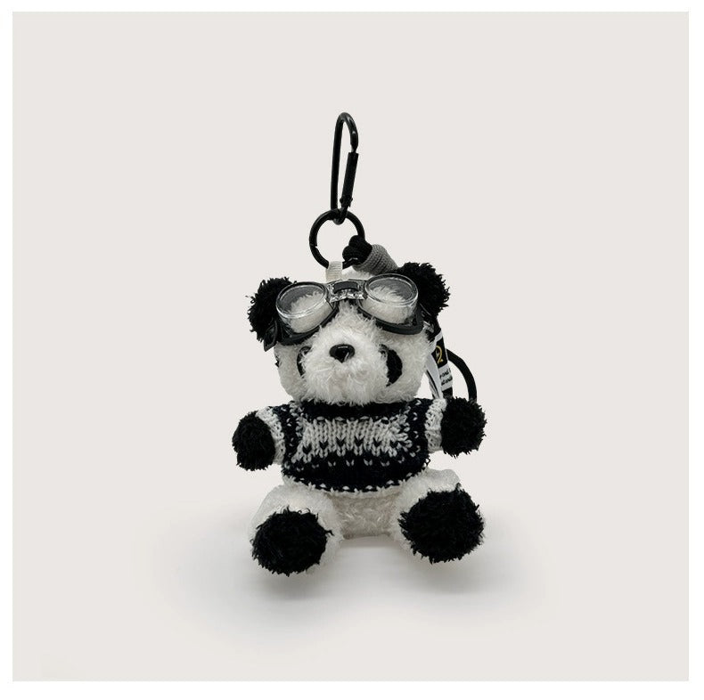 Panda plush keychain charm wearing blue and black striped knitted sweater with clear goggles
