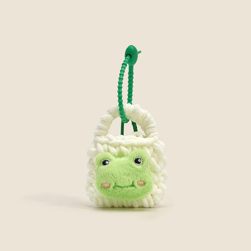 White and green plush mini bag charm with frog face design and green coiled cord