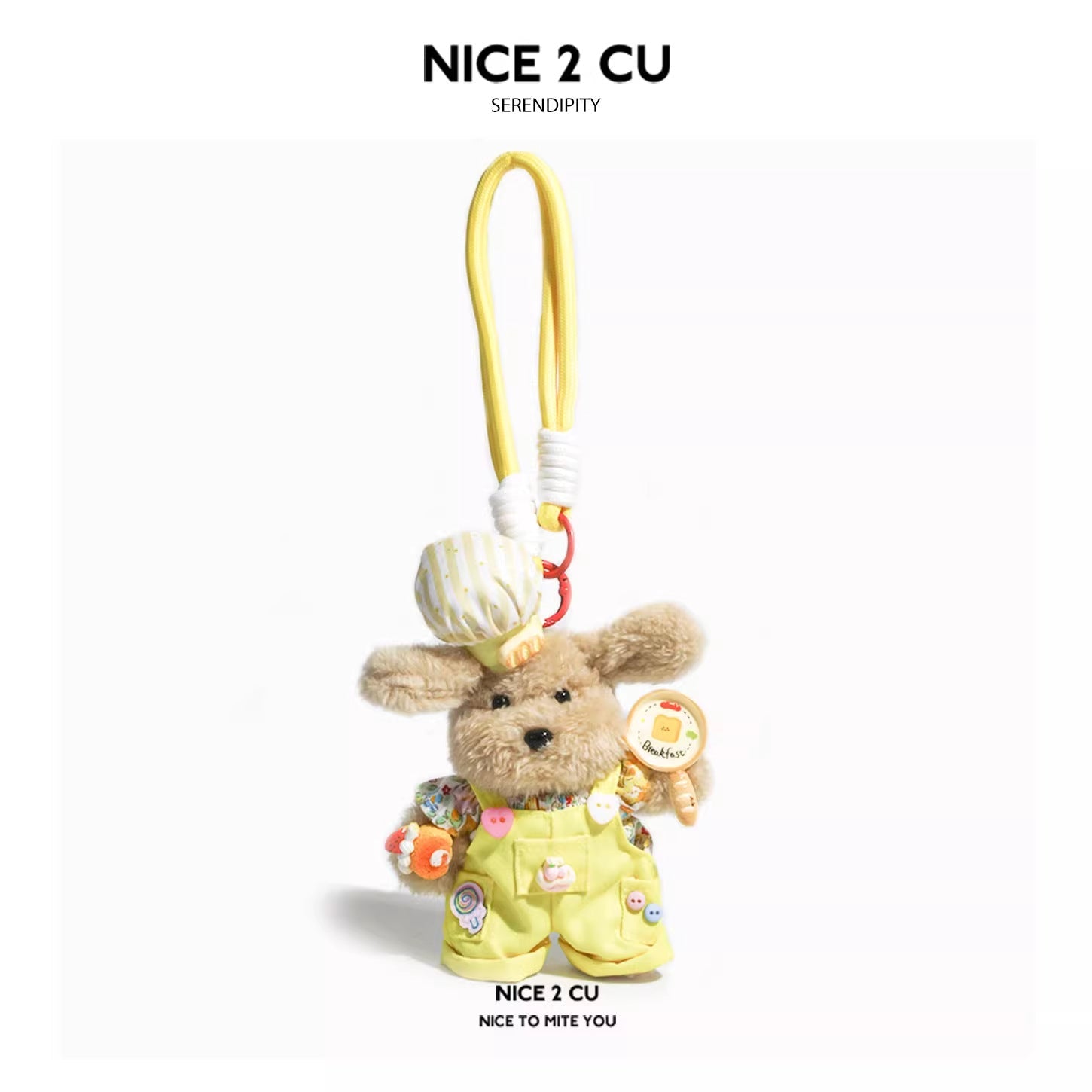 Kawaii plush dog pendant wearing yellow bib overalls, striped chef hat, food-themed pins, and holding a small breakfast prop