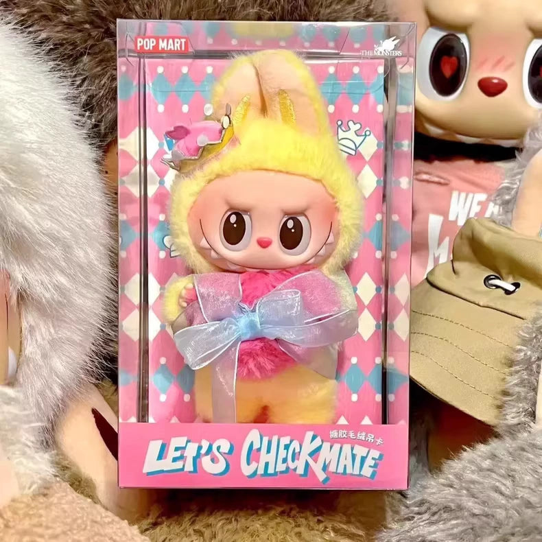 The POP MART Labubu Let's Checkmate Series – Pink Heart Bunny Plush Vinyl Doll, featuring a yellow and pink bunny outfit, is displayed against a colorful argyle background labeled LETS CHECKMATE—a must-have collectible.