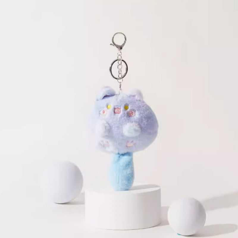 Blue and lavender kawaii plush cat keychain with yellow eyes, pink cheeks, and silver metal clip