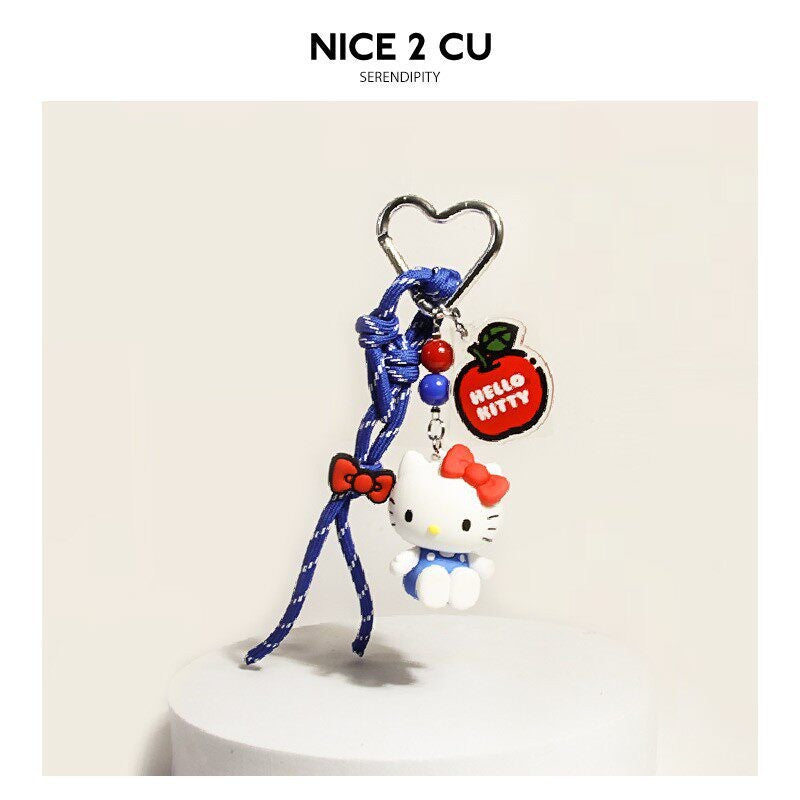 Blue cord hanging accessory with small white cat charm, beads, and fruit-themed round charm