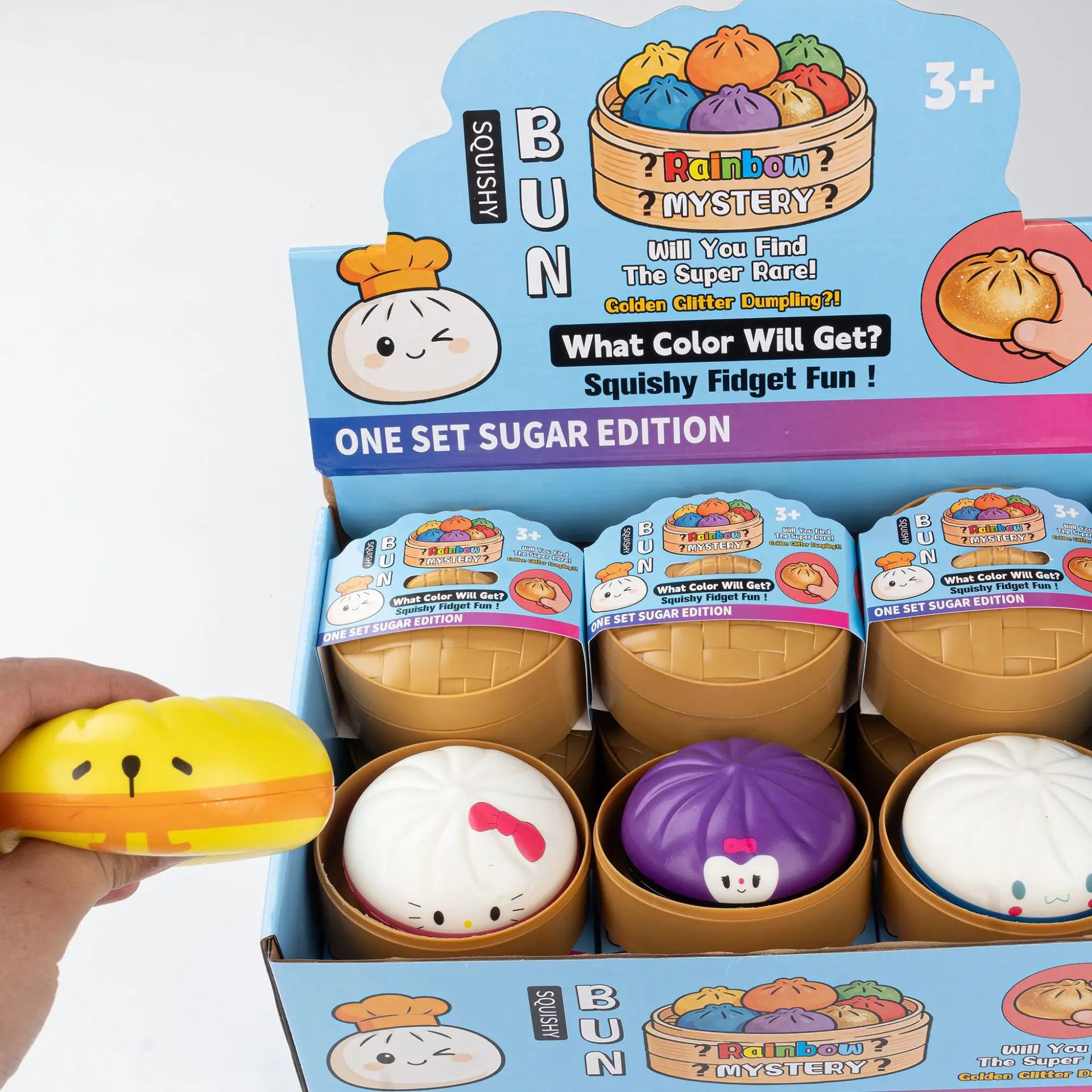 A hand squeezes a yellow Kawaii Character Squishy Bun Fidget Toy by ZoDoll, Sanrio-Inspired Sugar Edition, beside an open steamer box filled with 6 colorful cartoon designs, all set against a pink modern UI-inspired palette.