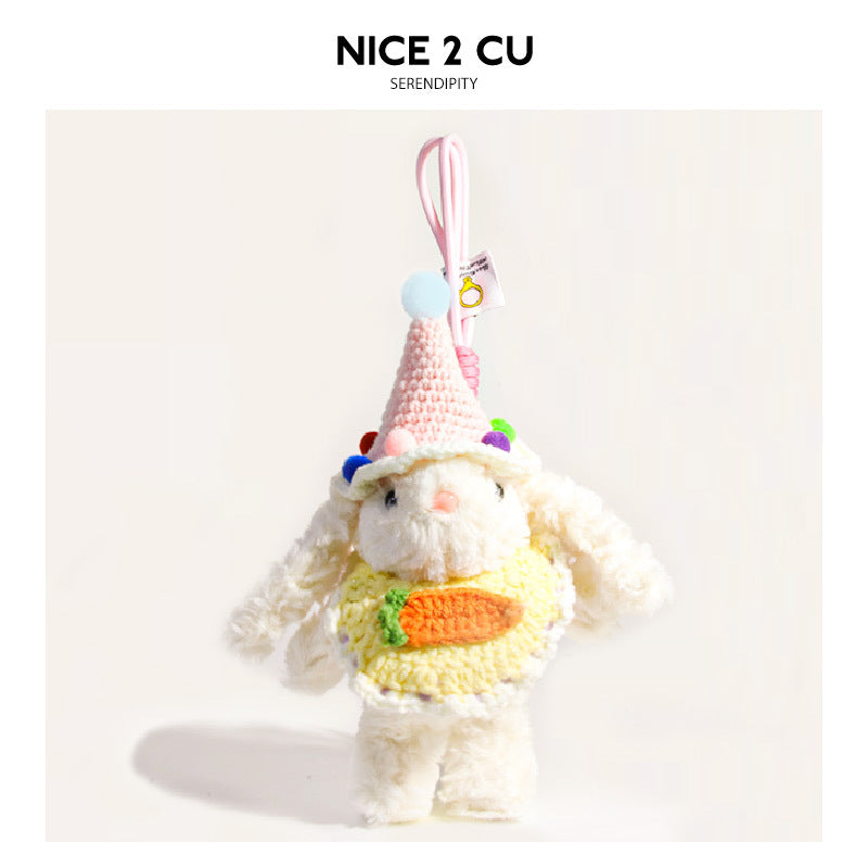 White plush rabbit charm wearing pink knitted cone hat with pom-pom and yellow carrot-motif top with pink hanging loop