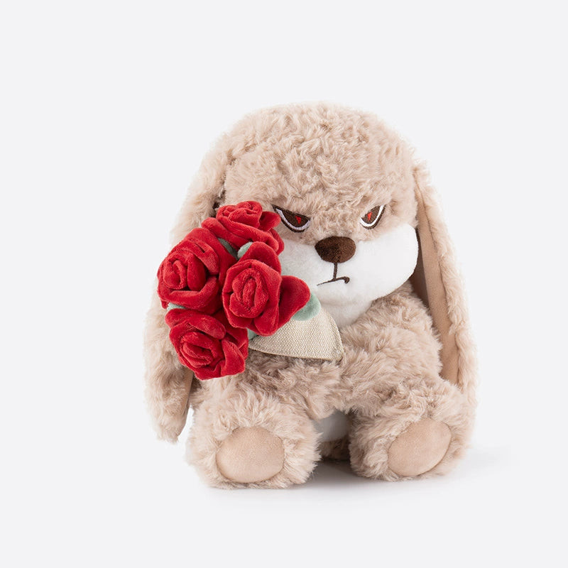 The ZEIO Rose-Holding Bunny Plush Toy (29cm) is a soft beige rabbit doll with a grumpy face, clutching a plush red rose bouquet—a charming touch for any nursery décor.