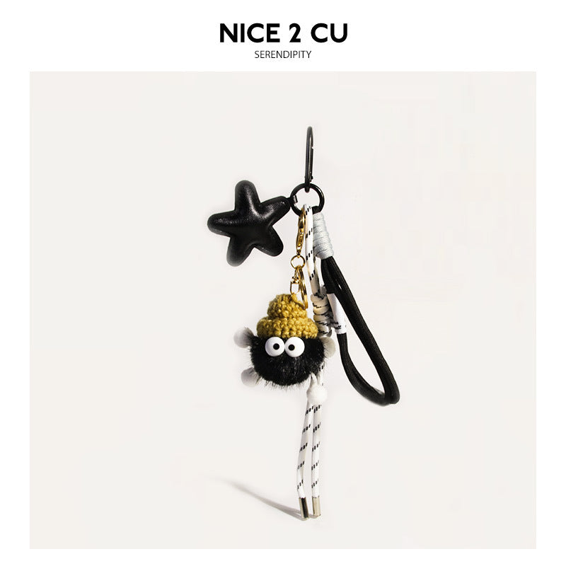 Black fluffy coal-ball bag charm with yellow knit hat, black star pendant, black-and-white braided cord, and gold clip