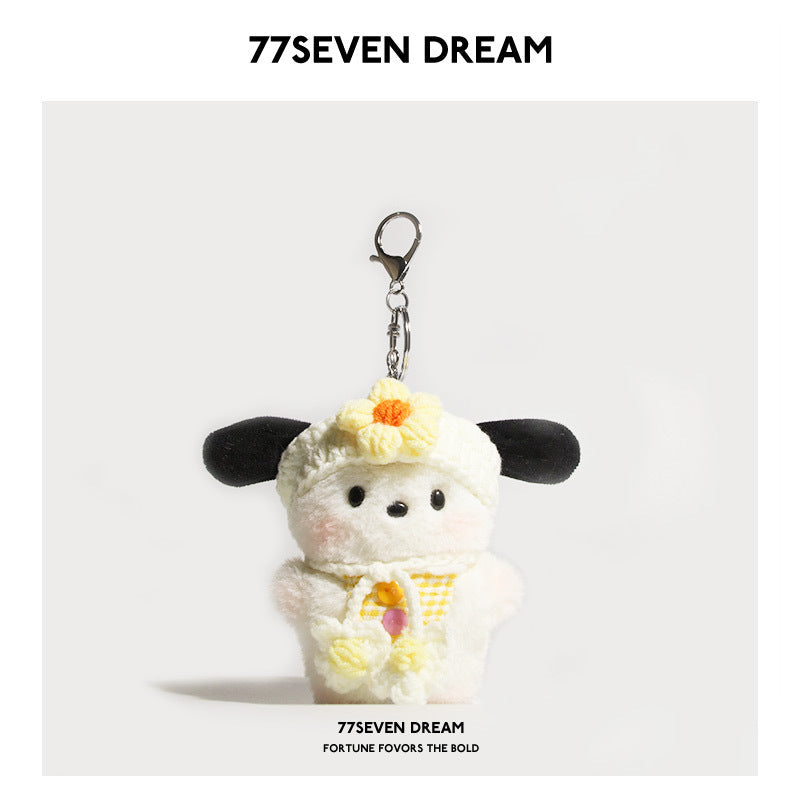 Kawaii dog plush keychain charm with yellow gingham bib and yellow flower hat detail on plain background