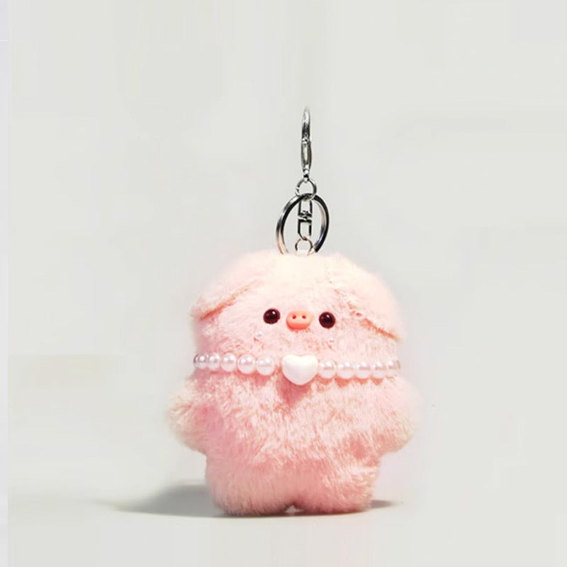 Pink plush pig keychain wearing a pearl-style bead necklace with heart center charm, silver clip