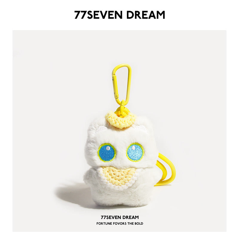 White cat plush charm with blue-outlined eyes and yellow crocheted bib, yellow carabiner clip