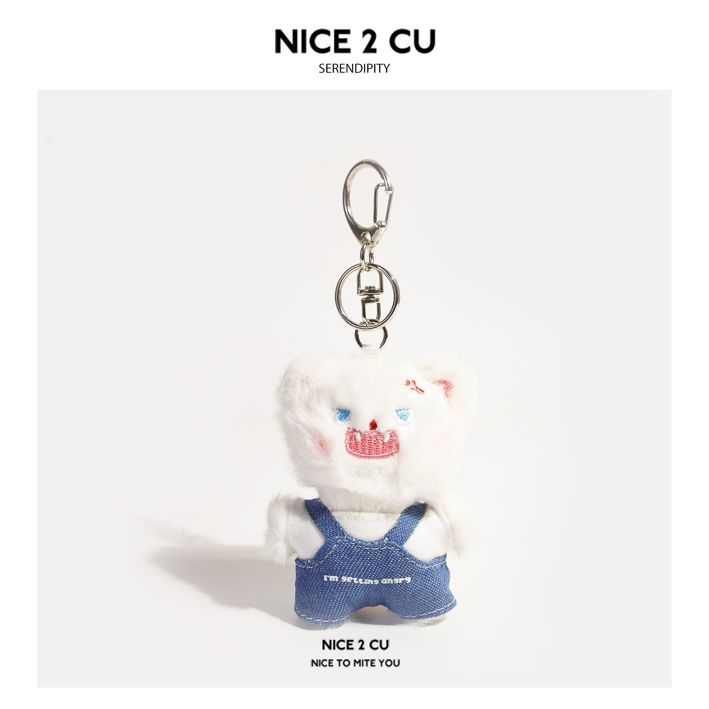 White fluffy cat plush keychain wearing blue denim overalls over a white shirt with silver clasp