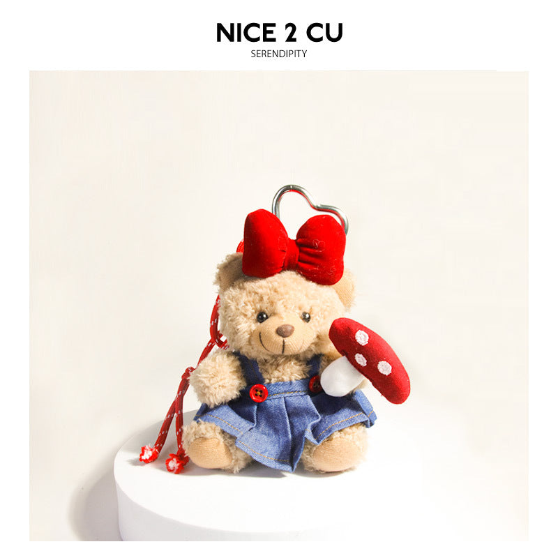 Tan teddy bear plush bag charm with red bow, denim skirt, polka-dot mushroom, and silver heart clip