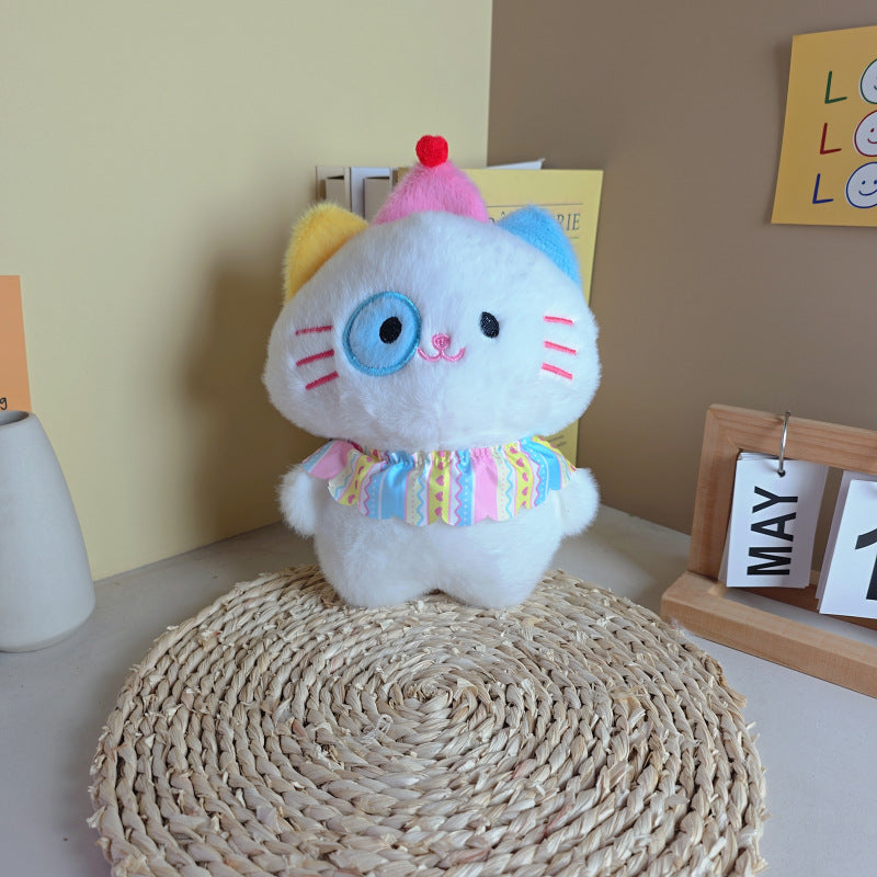 The ZoDoll Adorable 8.7" Cute Cat Plush Toy, a soft kawaii kitten stuffed animal with random eye color and colorful details, sits on a woven mat beside a May 12 calendar.