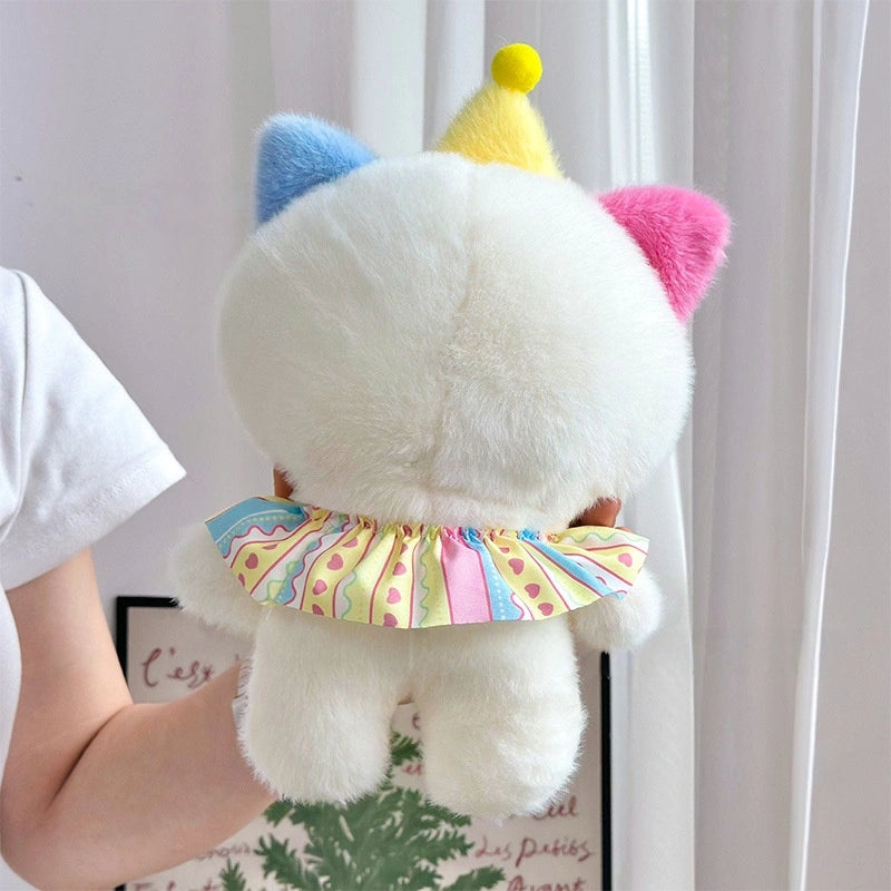 A person holds the ZoDoll Adorable 8.7" Cute Cat Plush Toy, a soft kawaii kitten stuffed animal with white fur, pastel blue and pink ears, a yellow party hat, and a frilled multicolored skirt. The toy is shown from the back.