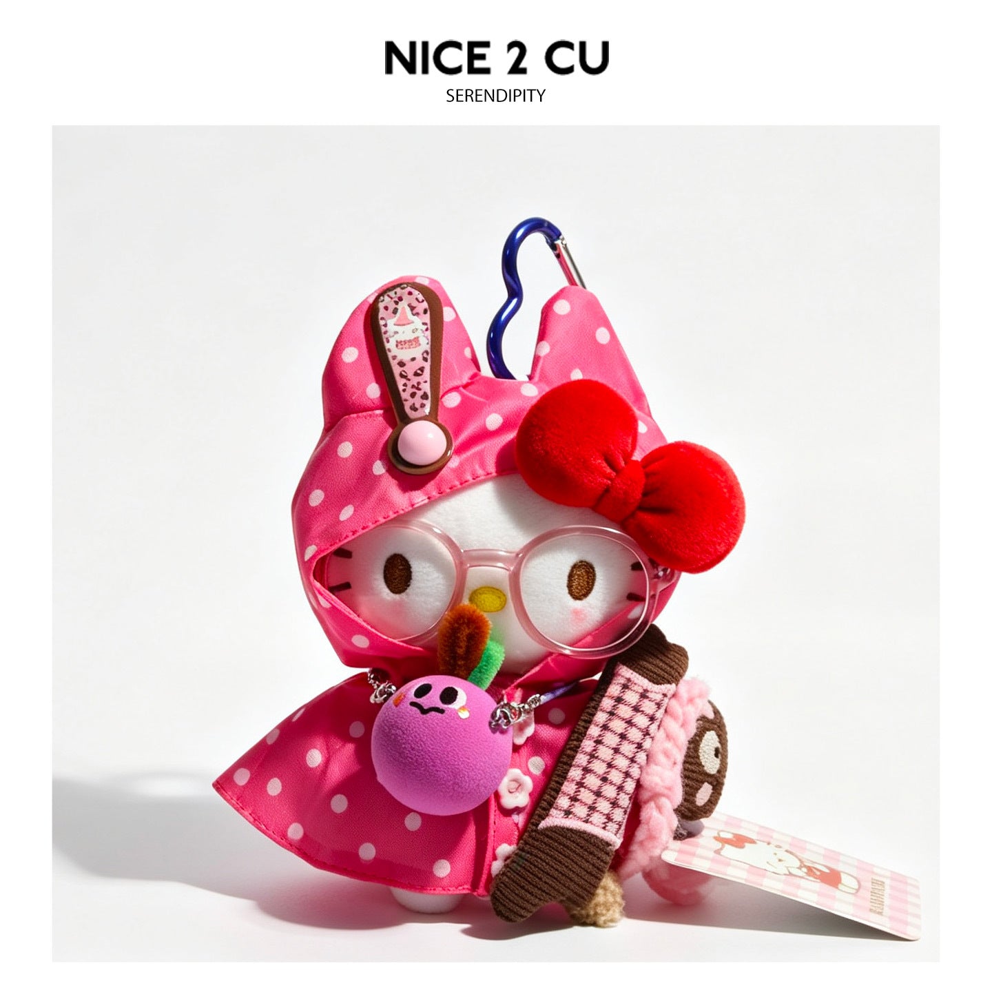 Pink polka-dot raincoat kawaii cat plush charm with bunny-ear hood, red bow, pink glasses, and decorative dangling charms