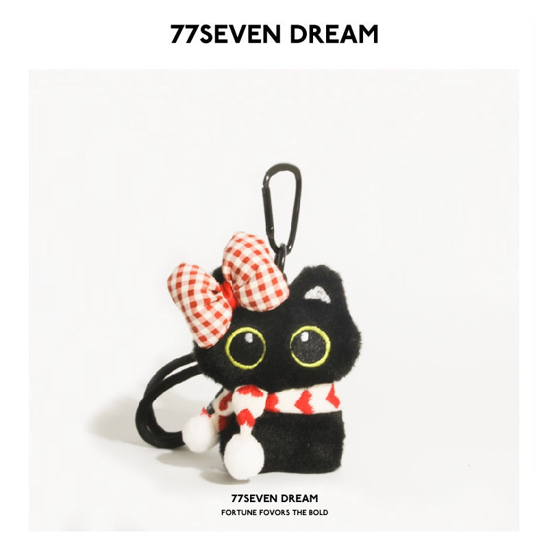 Black cat plush keychain with large yellow-outlined eyes, red-and-white checkered bow, and heart-patterned scarf