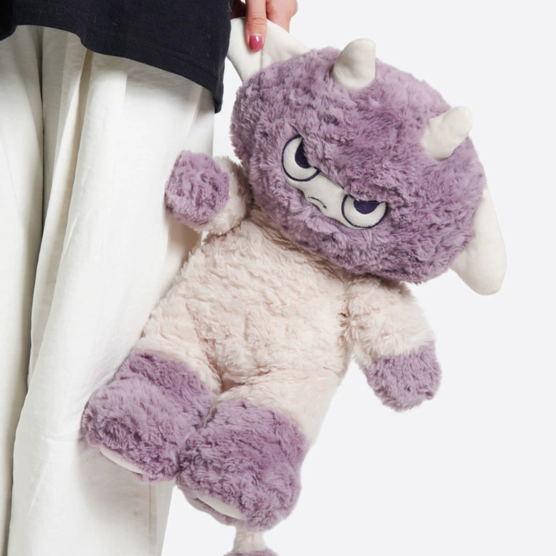 A person holding the ZEIO Lilith Demon Lamb Plush Toy 32cm, a soft stuffed animal sheep with purple horns, purple and beige fur, and an annoyed expression.