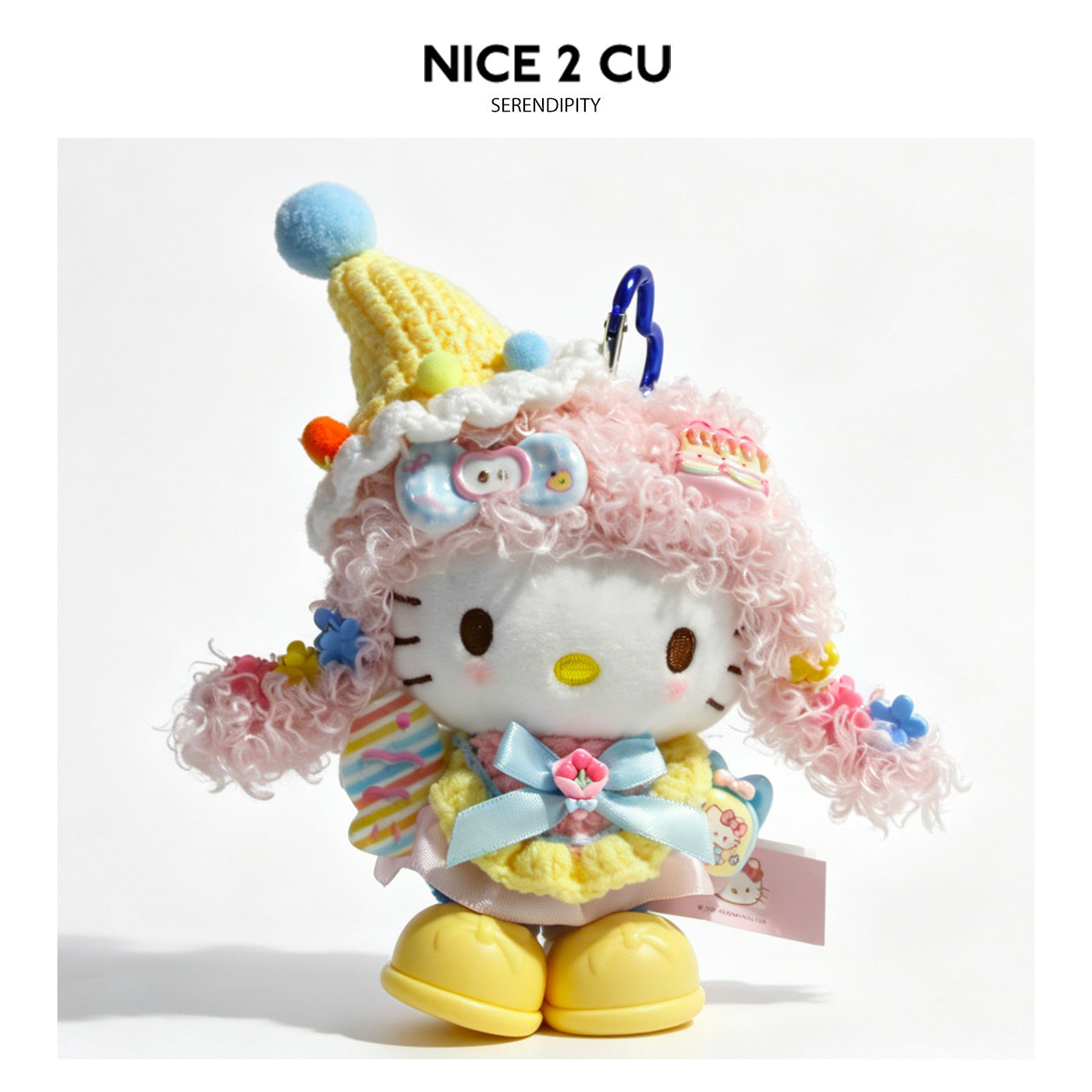Kawaii cat plush bag charm in party princess style with curly pink hair, tall yellow knit hat, and colorful accessories