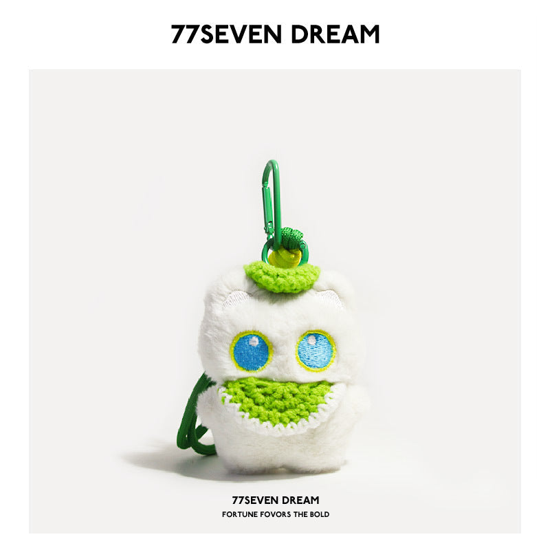 White cat plush charm with blue-outlined eyes and green crocheted bib, green carabiner clip