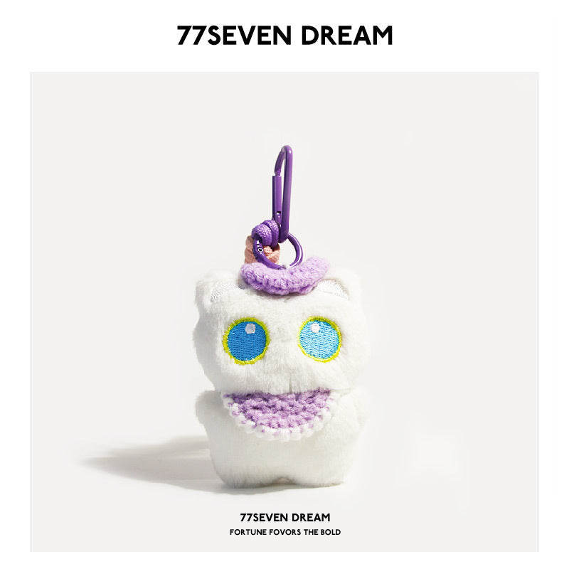 White cat plush charm with blue-outlined eyes and purple crocheted bib, purple carabiner clip