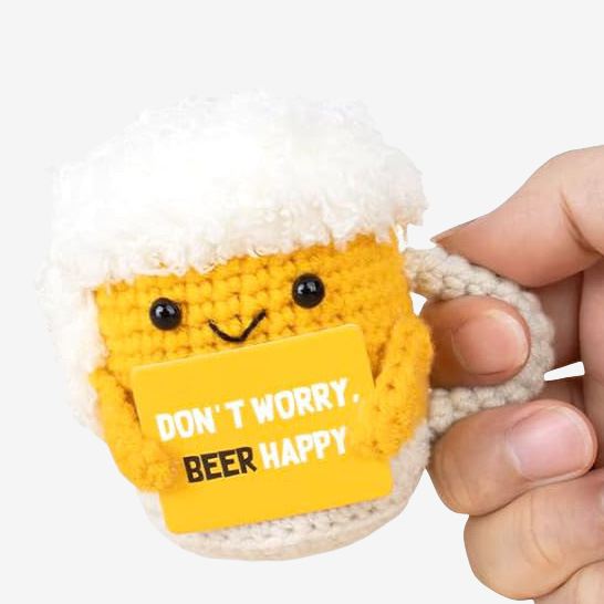 A hand holds ZoDoll's Don't Worry Beer Happy Crochet Amigurumi—a cheery beer plush shaped like a smiling mug with a yellow sign, perfect for good vibes, relaxation, and quirky beer-themed gifting.