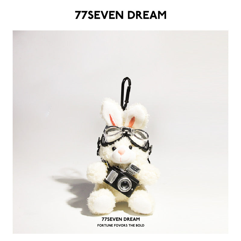 White rabbit plush keychain charm wearing aviator goggles and holding a miniature black camera with carabiner clip