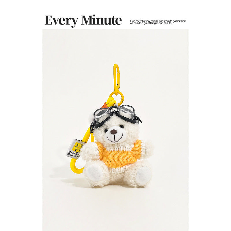 White bear plush keychain charm wearing aviator goggles and a yellow-and-white knit sweater with yellow carabiner clip