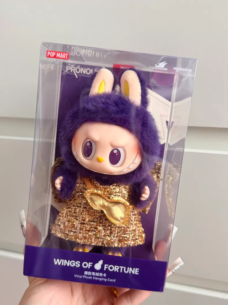 The POP MART Labubu × PRONOUNCE Wings of Fortune Limited Edition Designer Plush Vinyl Toy is a boxed collectible featuring Labubu in a purple bunny costume and gold dress.