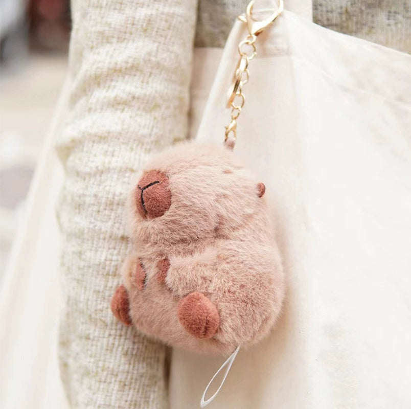 The ZEIO Guinea Pig Plush Keychain 11cm is a soft, light brown mini cavy charm attached to a cream bag, creating an irresistibly cute accessory.