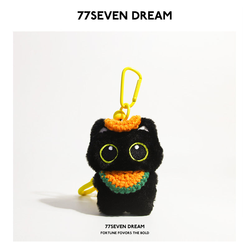 Black cat plush charm with green-outlined eyes and orange crocheted bib with green trim, yellow carabiner