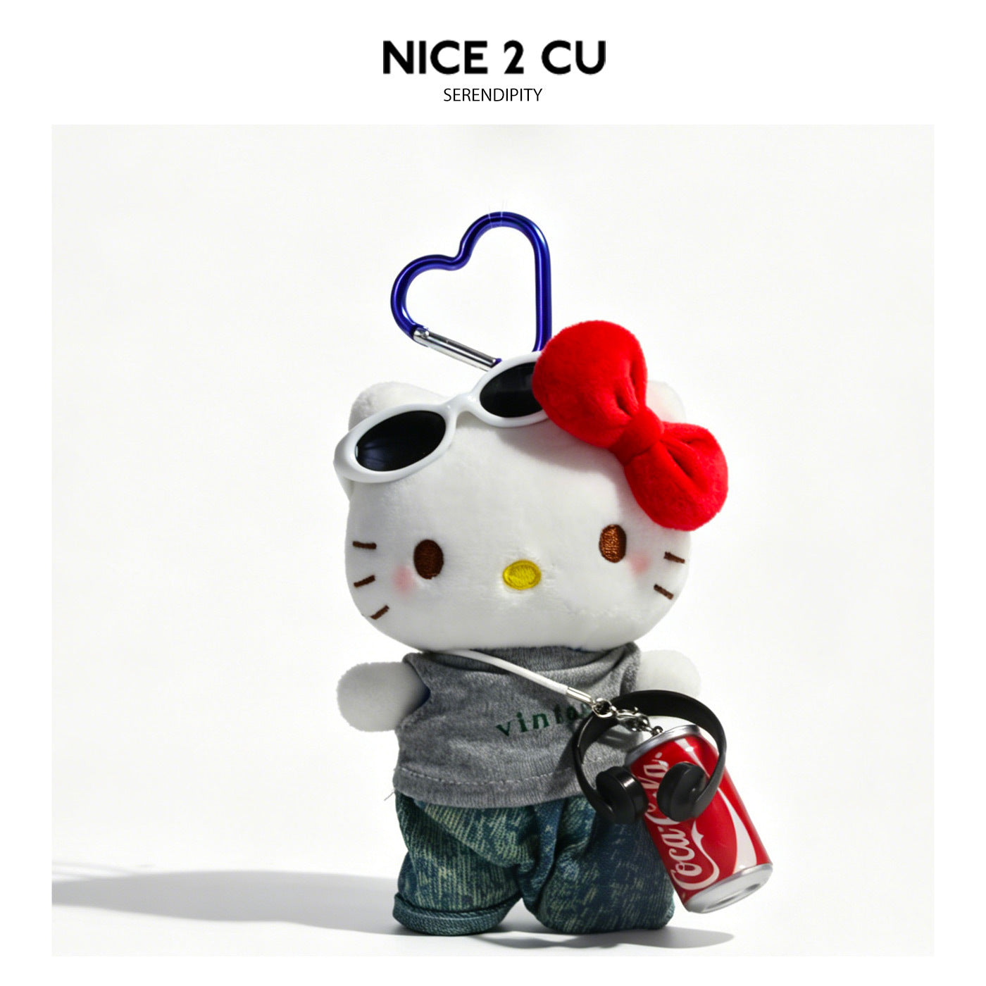 Cartoon cat plush charm wearing sunglasses, gray top, blue jeans, and cola can accent with blue heart clip