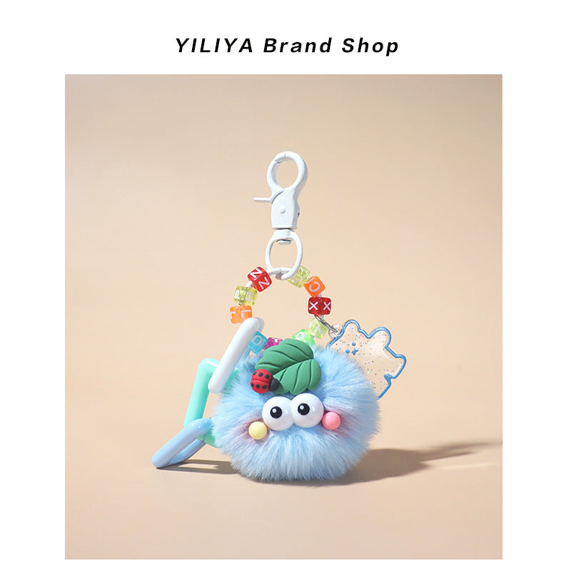 Light blue fluffy pom-pom charm with small clip attachment, pastel translucent beads, plastic ring shapes, and ladybug leaf d
