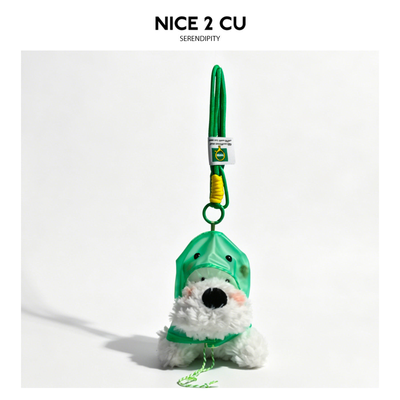 White fluffy dog keychain charm wearing a translucent green hooded raincoat with pointed ear accents