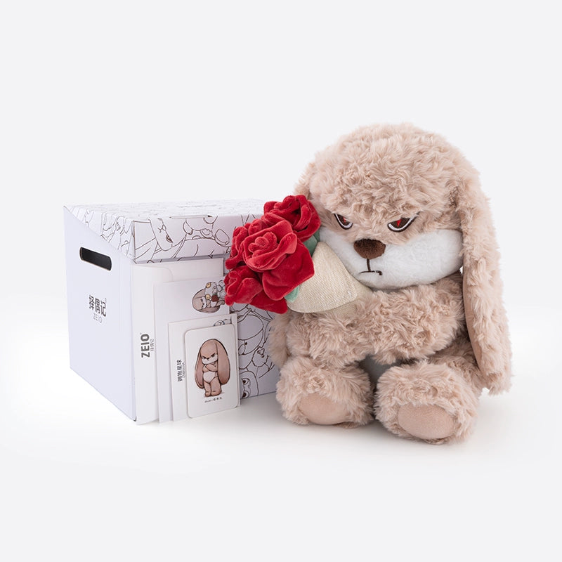 The ZEIO Rose-Holding Bunny Plush Toy (29cm) is a soft rabbit doll with an angry expression, holding a plush red rose bouquet, shown beside a white box and two illustrated cards on a plain background.