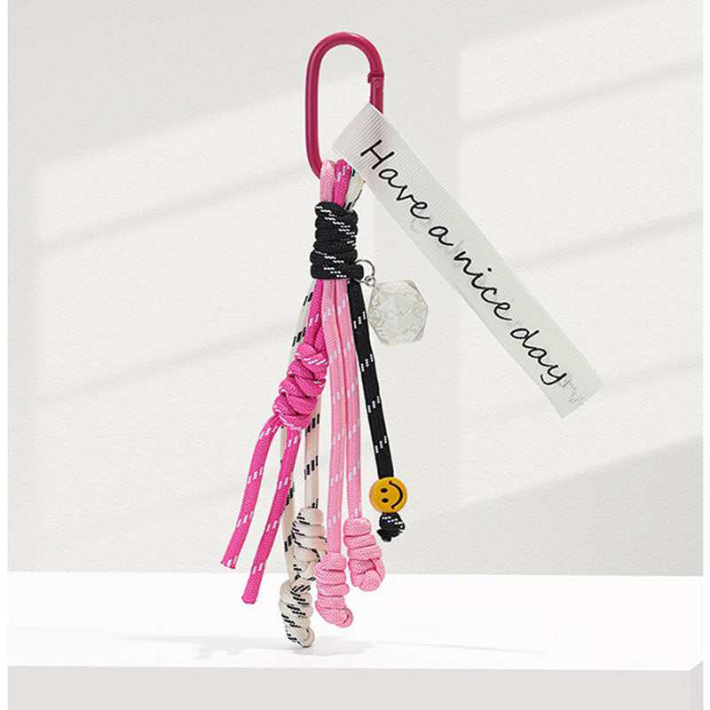 Rose carabiner braided rope bag charm with pink and black cord strands and white printed fabric tag
