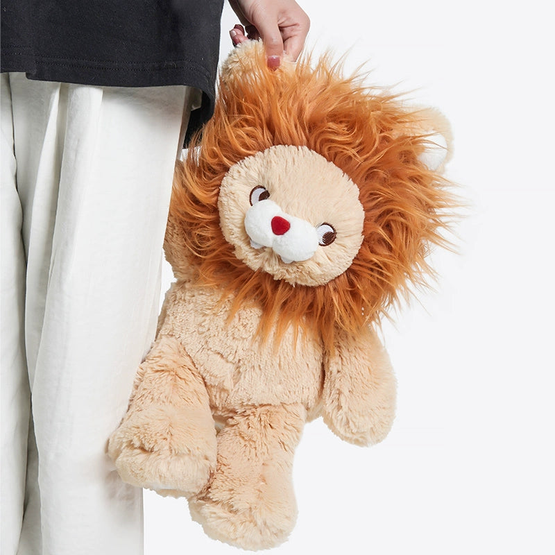 A person in white pants holds the ZEIO Lion Plush Toy 30cm – Soft Cuddly King of the Jungle Stuffed Animal by its mane against a plain white background.