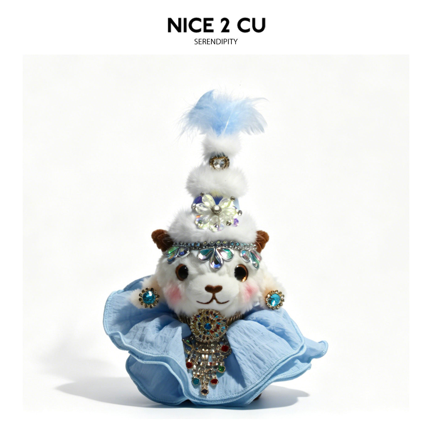 White plush lamb figurine in a pale blue princess outfit with layered skirt, blue feather topper, and iridescent jewel decora