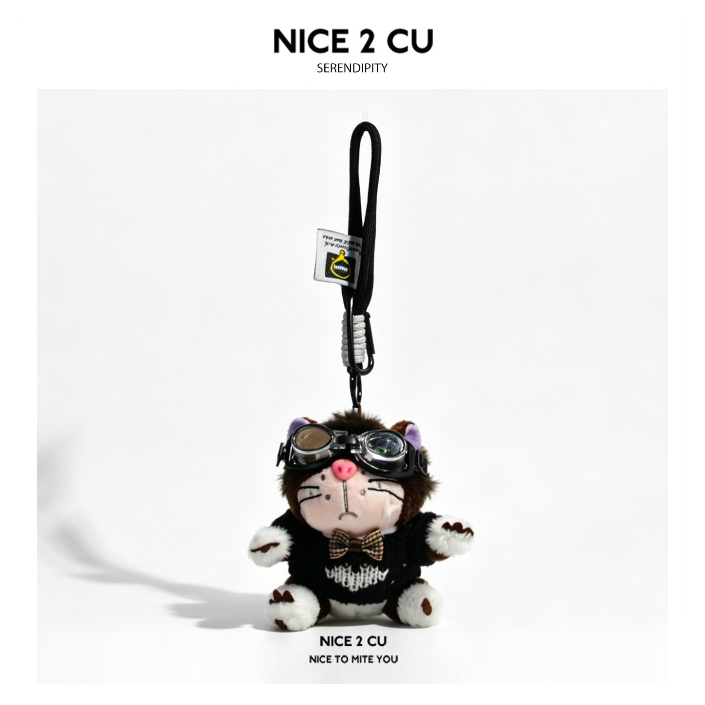 Brown cat plush keychain styled with aviator goggles and a small plaid bow tie on a dark outfit