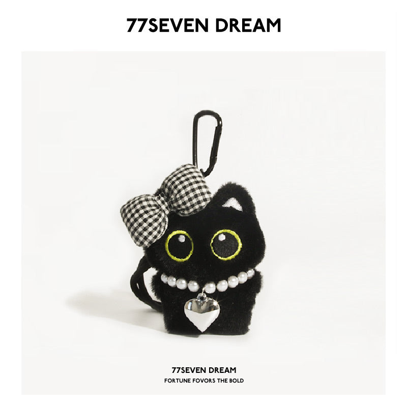 Black cat plush keychain with large yellow-outlined eyes, black-and-white checkered bow, and pearl heart necklace
