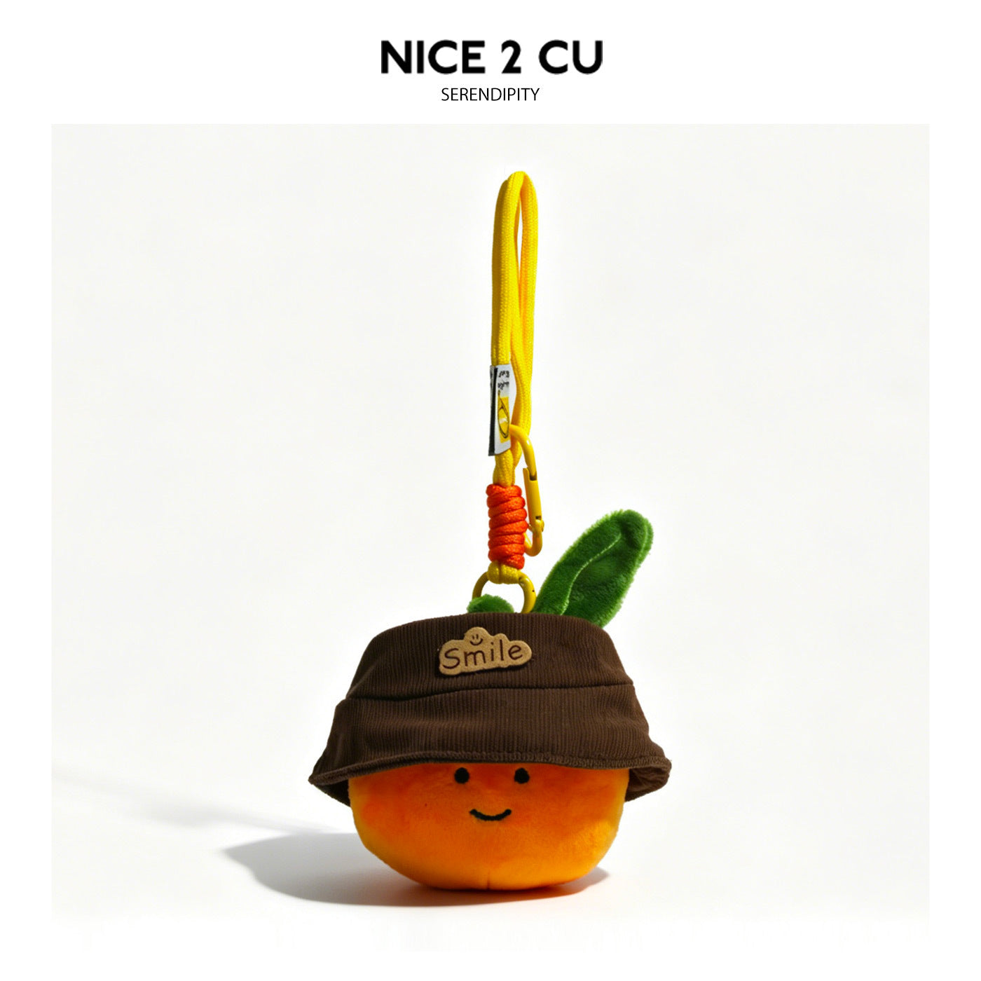 Smiling orange plush charm wearing a brown bucket hat with a tan Smile patch and green leaf, hanging from a yellow carabiner 