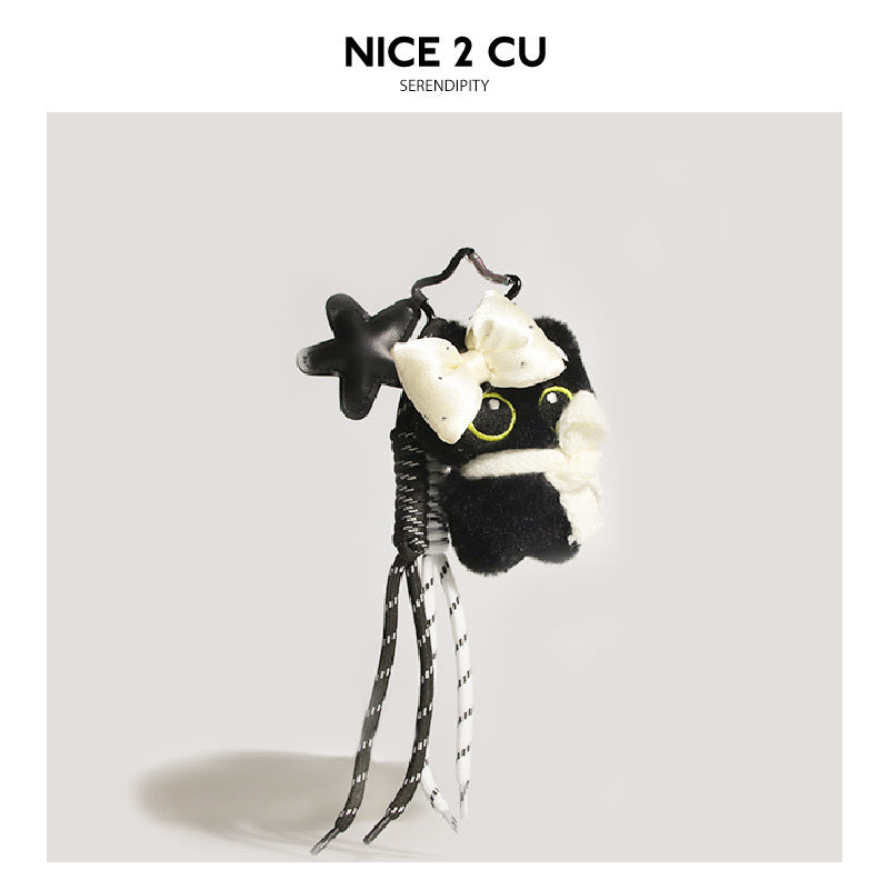 Black cat plush charm with white scarf wrap, matte black star pendant, and black-and-white braided tassel cords
