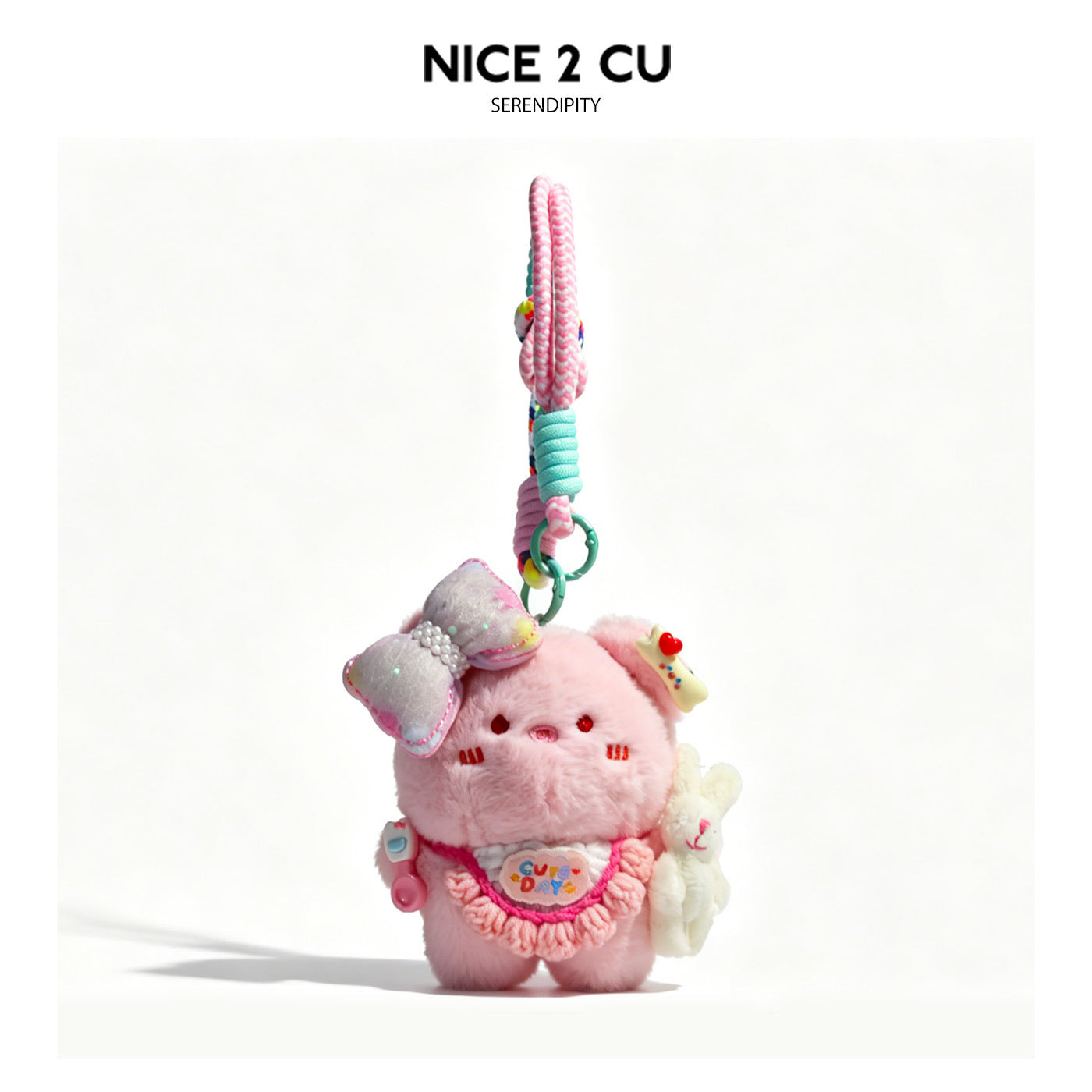Kawaii pink pig plush bag charm wearing a crocheted ruffle bib and pearl bow, holding a small white rabbit, with braided pink
