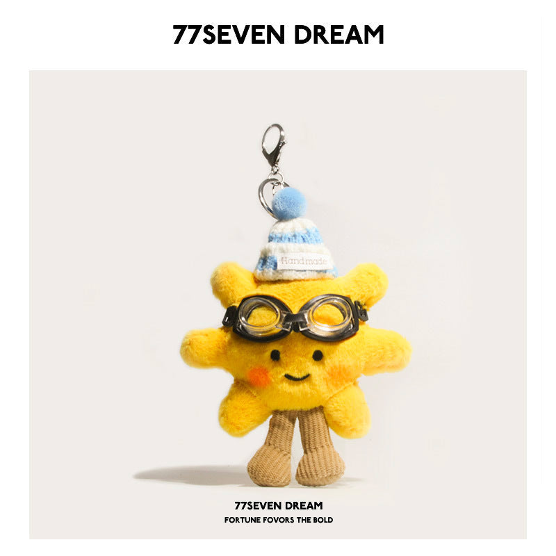 Yellow sunflower plush charm with blue-and-white striped hat and black toy goggles