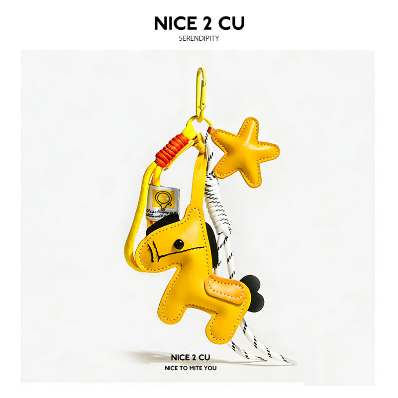 Yellow leather-look pony and star charm keychain with orange coil detail and white cord